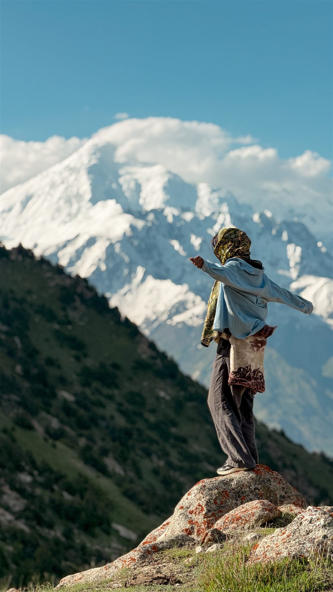 A traveller pointing out peaks from a viewpoint above the Hunza valley