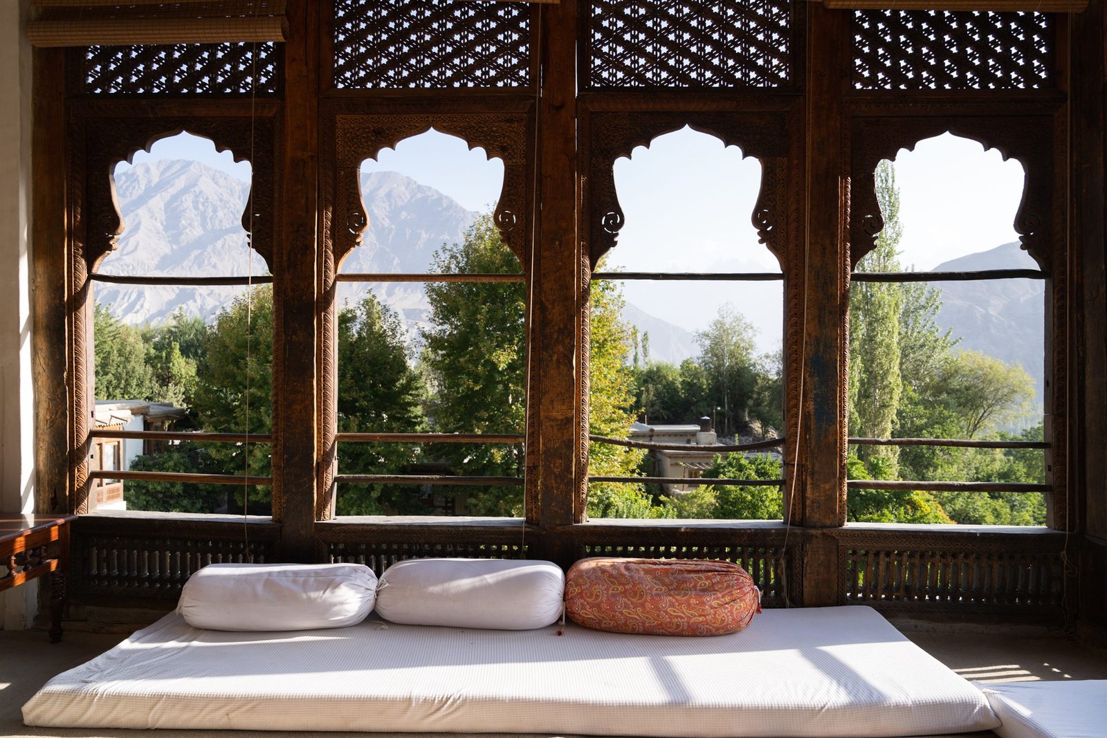 The white and timber facade of Khaplu Fort above its stone-walled garden