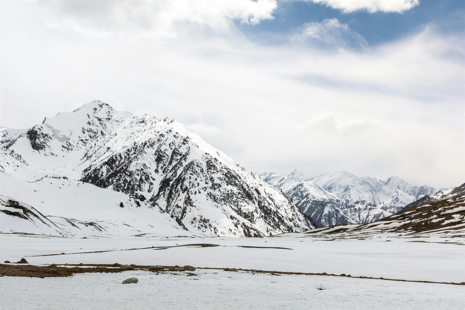 Snow-covered peaks above the flat, high ground of Khunjerab Pass