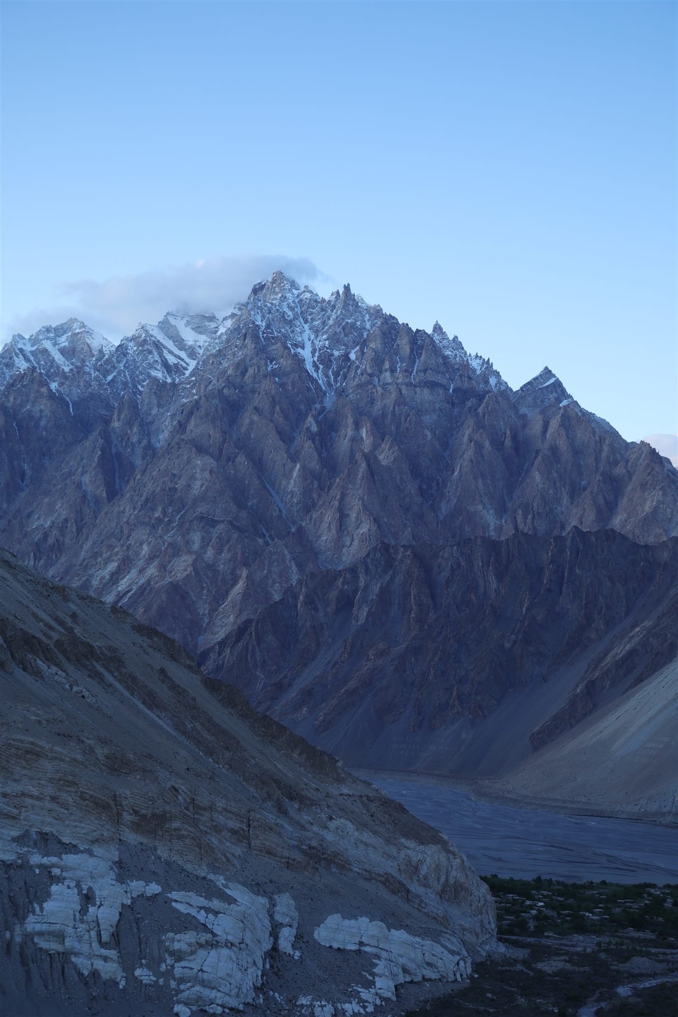 The Passu Cones and village lit by evening light beneath a clouded sky