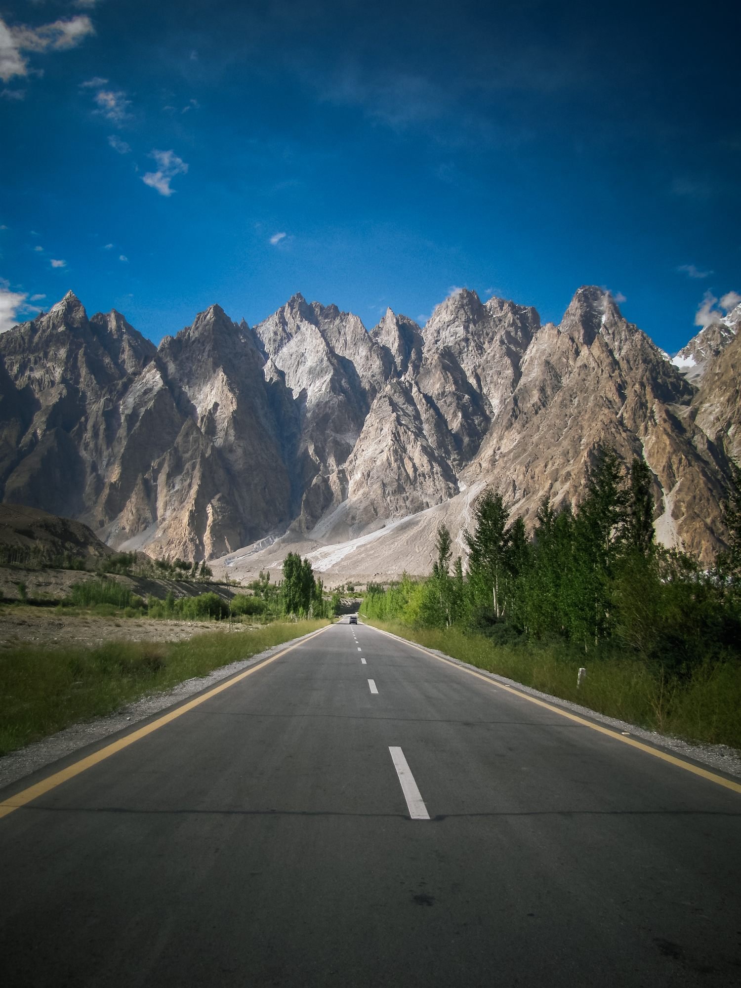 The Karakoram Highway running straight toward the jagged Passu Cones